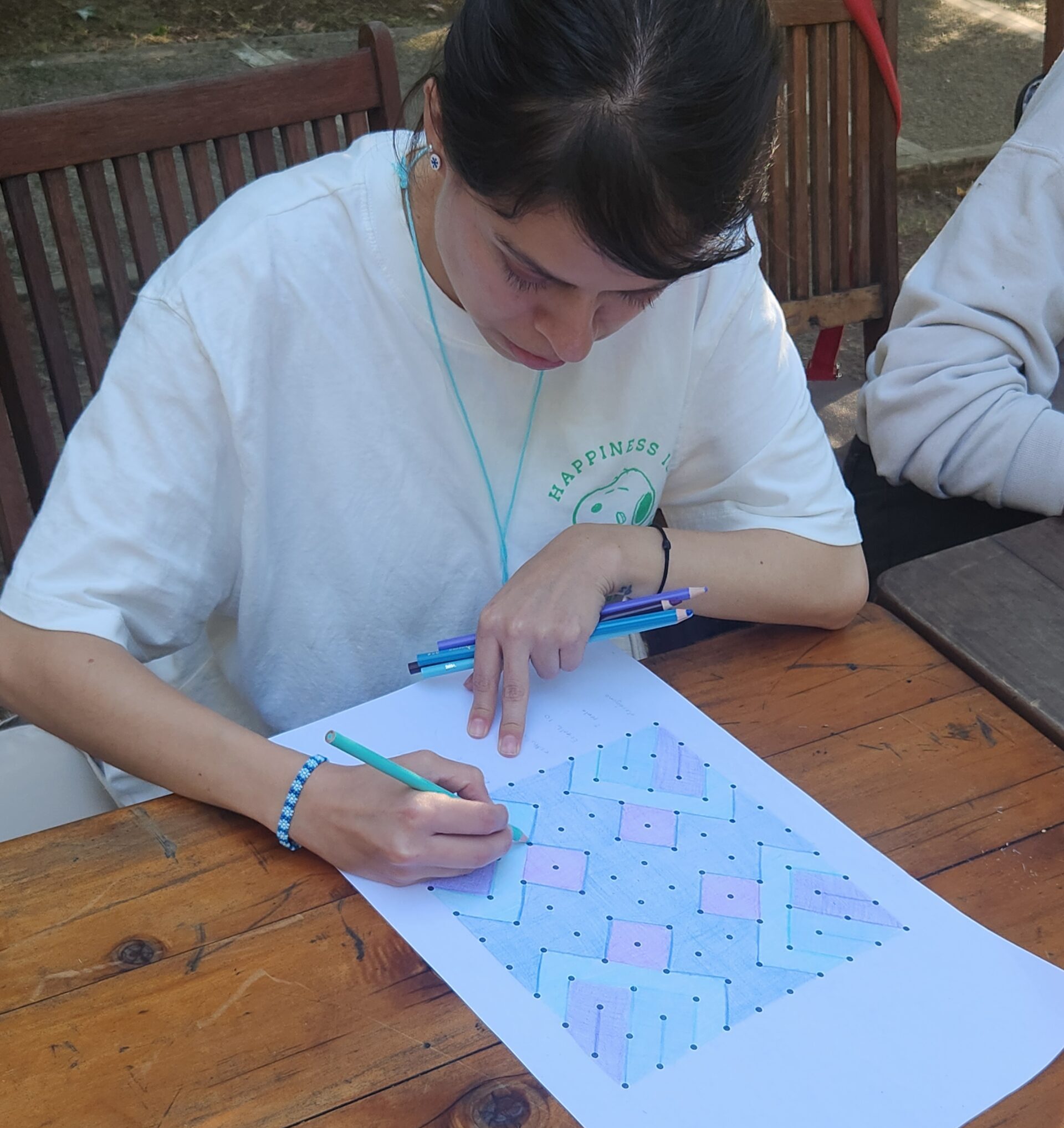 Participante dibujando y coloreando una estructura visual de Cymaticon